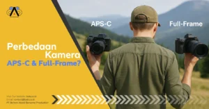 Seorang fotografer pria berdiri di alam terbuka dengan latar pegunungan, memegang kamera APS-C di tangan kanan dan kamera Full-Frame di tangan kiri untuk menunjukkan perbedaan ukuran kamera.