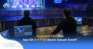 Operator event sedang mengendalikan audio di Front of House (FOH) konser dengan mixer dan monitor menyala, panggung bercahaya biru putih. Apa Sih Arti FOH dalam Sebuah Event?