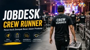 Crew runner profesional sedang membawa perlengkapan produksi di area backstage event dengan suasana panggung konser dan tim produksi yang sibuk bekerja.